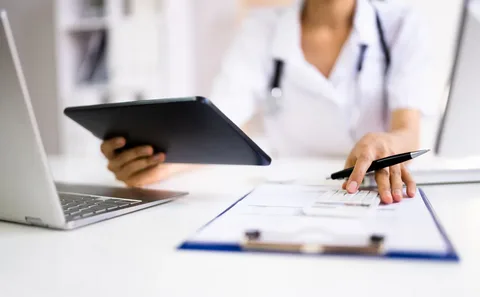 Medical billing specialist reviewing claims on tablet
